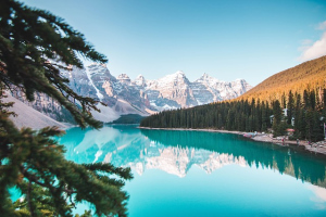 Ein kristallklarer, türkisfarbener Bergsee mit Spiegelung der schneebedeckten Berge für die Plattform trip´dip.